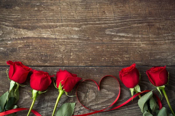 Rosas rojas y fondo de cinta en forma de corazón —  Fotos de Stock