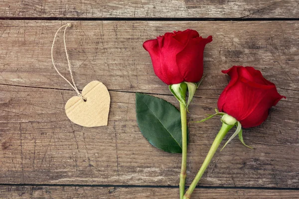 Red roses and heart on wooden background — Stock Photo, Image