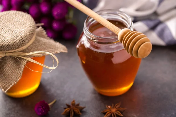 Természetes méz üvegedénybe és merítőkanál — Stock Fotó