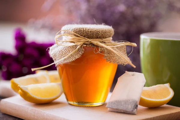 Чашка чая с медом и лимонным фоном — стоковое фото