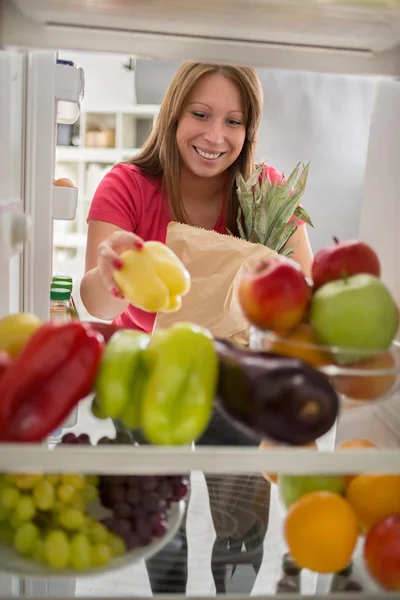 Hausfrau war auf dem Markt und legte Paprika in Kühlschrank — Stockfoto