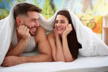 Battaniyenin altında gülümseyen Çift 