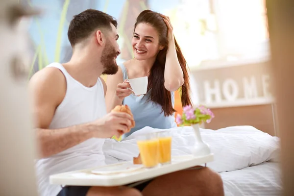 Молодая улыбающаяся пара с роскошным завтраком — стоковое фото