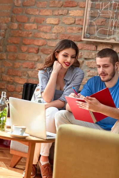 Studenter med anteckningsboken i café — Stockfoto