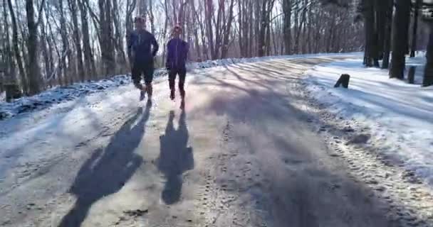 Pareja invierno corriendo en nieve — Vídeo de stock