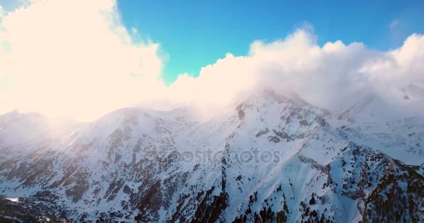 Vuelo aéreo sobre la montaña nevada en invierno — Vídeo de stock