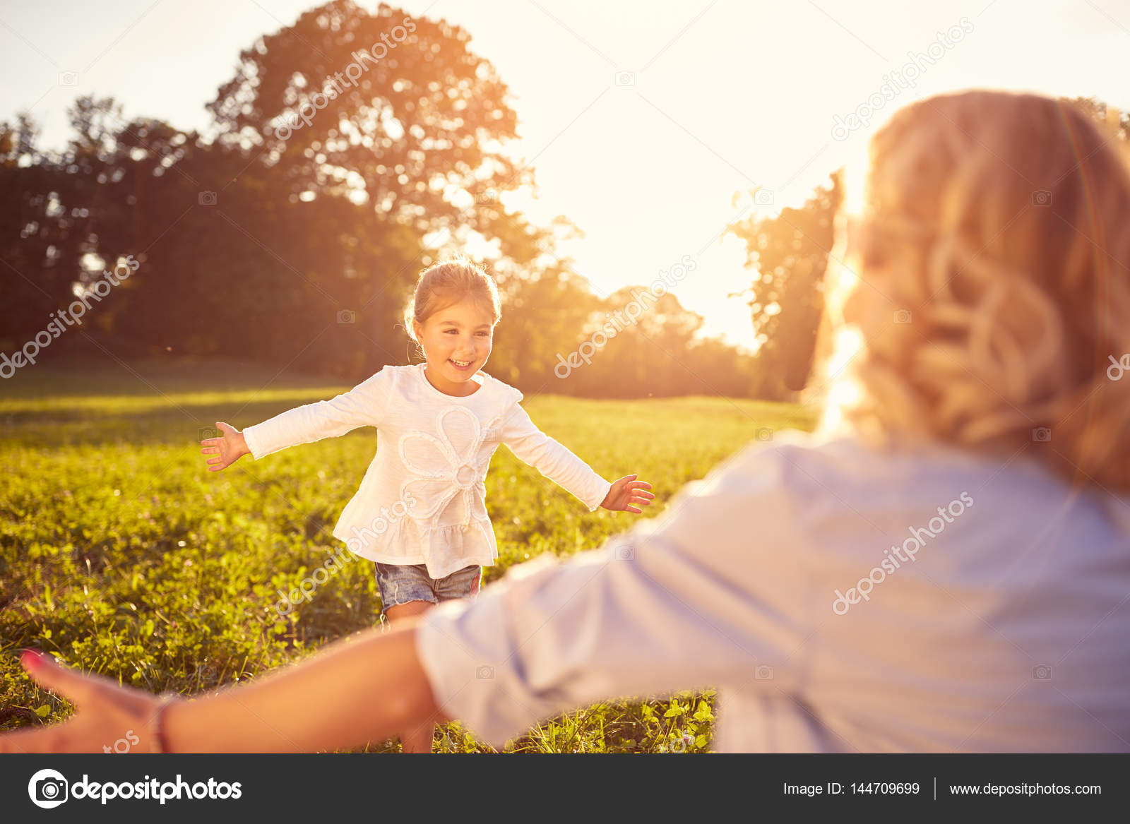 Мама с ребенком в парке. Ребенок бежит навстречу маме. Идти на встречу маме. Маленькая девочка идет сзади. Идти на встречу маме.