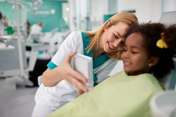 Tandartsassistente kijken in de spiegel meisjes tanden — Stockfoto