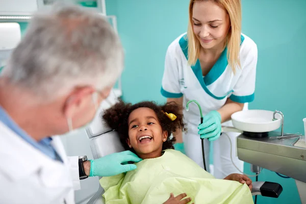 Kleine schwarze Patientin zeigt ihrem Zahnarzt Zähne — Stockfoto