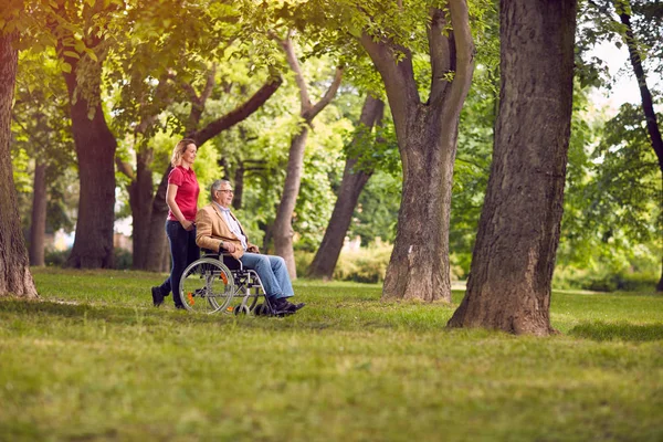 Starší muž šťastný čas strávený s rodinou v invalidní vozík a dcera v parku — Stock fotografie