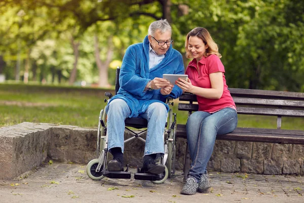 Heureux homme en fauteuil roulant avec fille utilisant table — Photo