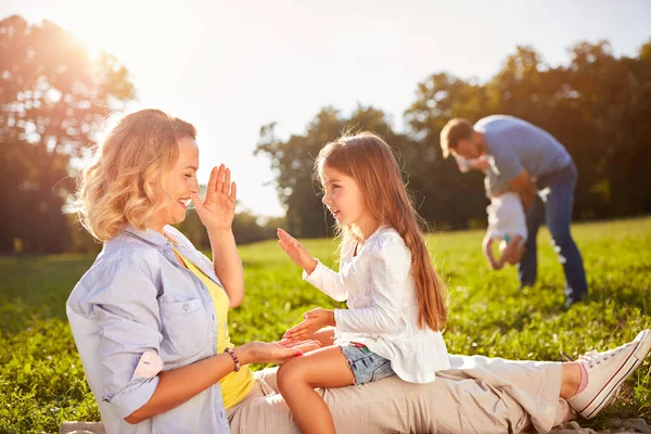 Lycklig kvinna med dotter spela på picknick — Stockfoto