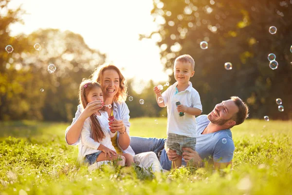 Famille avec enfants souffler des bulles de savon — Photo