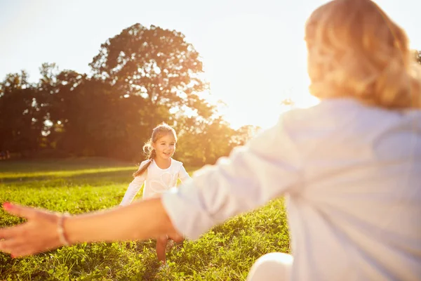 Chica corriendo a su mamá en el parque — Foto de Stock