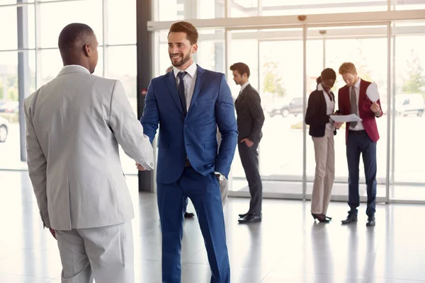 Worker at entrance shake hands with partner — Stock Photo, Image