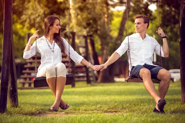 Pasangan yang bermain ayunan di luar ruangan — Stok Foto