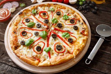 otlar ve taze madde ile masanın üzerinde yatan pizza