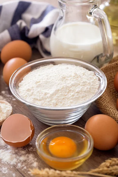 Bowl of wheat flour with eggs on the wooden background — Stock Photo, Image