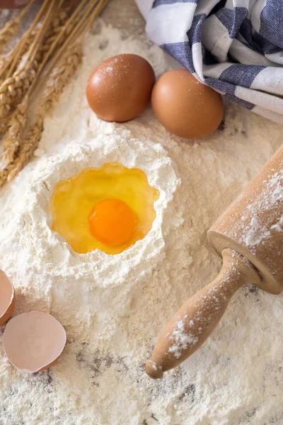 Eggs, dough, flour and rolling-pin on wooden table — Stock Photo, Image