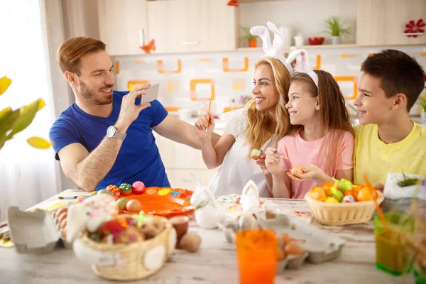 Father take photo to his family while coloring eggs — Stock Photo, Image