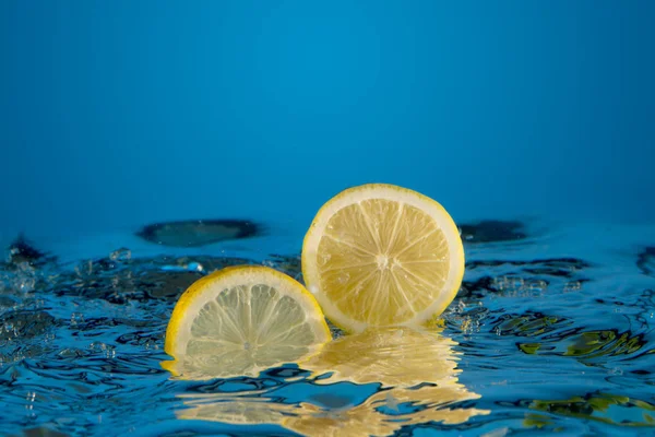 Limón amarillo caído en el agua — Foto de Stock