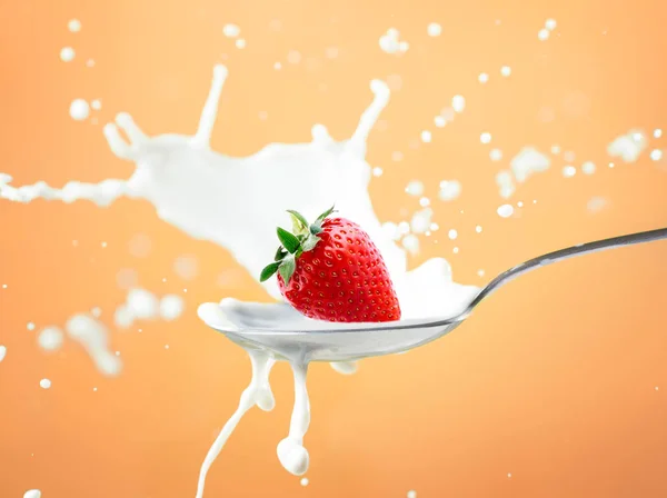 Strawberry splash in milk isolated on yellow — Stock Photo, Image