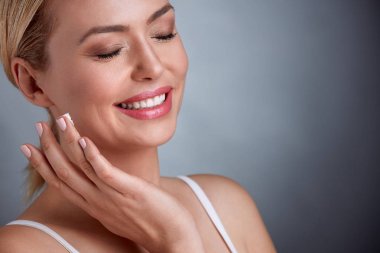 Orta yaşlı kadının yüz kremi 