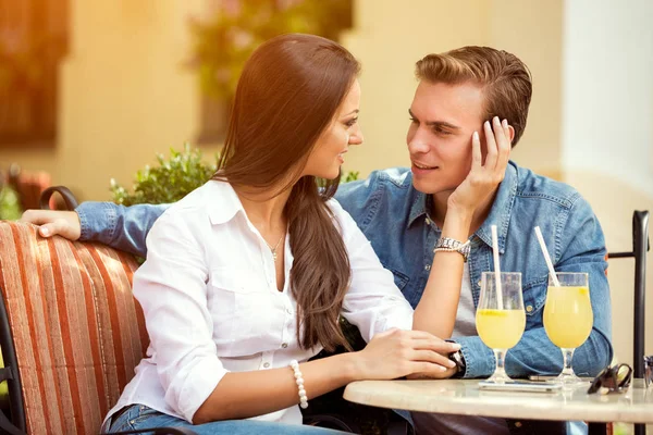 Vackra unga älskande par sitter tillsammans i café — Stockfoto