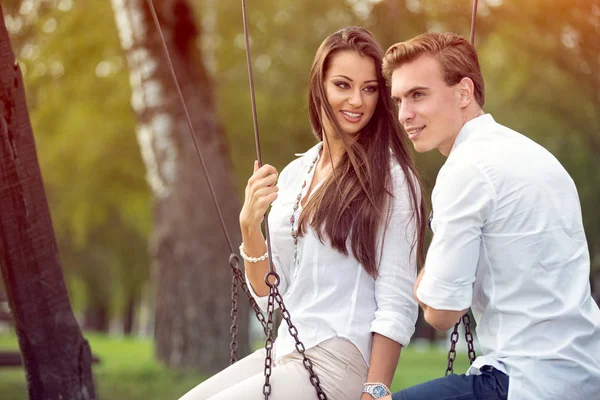 Couple in love on swings — Stock Photo, Image