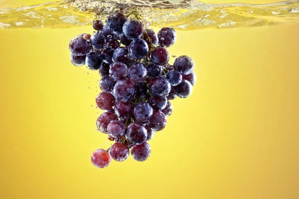 Разбрызгивание винограда в резервуаре воды — стоковое фото