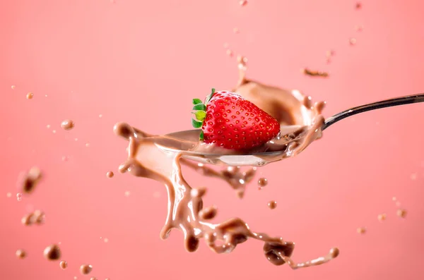 Truskawka splash w mleku na czerwonym tle — Zdjęcie stockowe