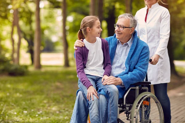 Senior man op rolstoel met zijn kleindochter — Stockfoto