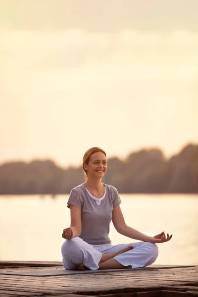 Persona femenina en el río en pose de yoga — Foto de Stock