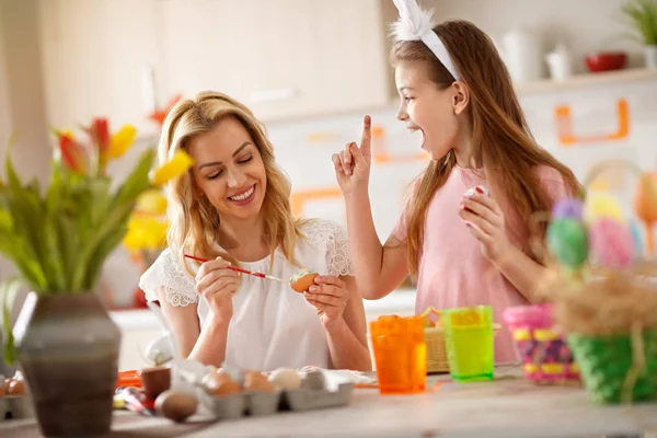 Mother and daughter enjoy while painting eggs — Stock Photo, Image