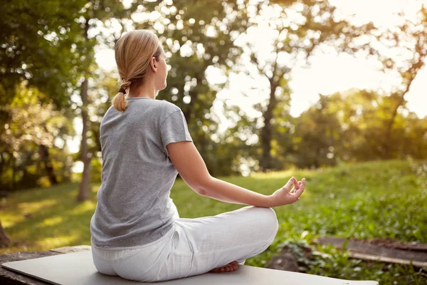 Femme en pose de lotus dans le parc — Photo