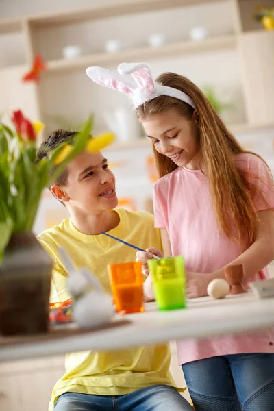 Jongen en meisje schilderij eieren voor Pasen — Stockfoto