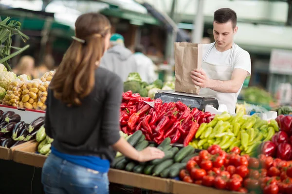 Продавець вимірювальних овочів клієнт в продуктовому магазині — стокове фото