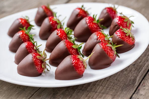 Strawberries covered with dark chocolate — Stock Photo, Image