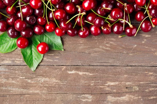 Cerezas maduras sobre mesa de madera —  Fotos de Stock