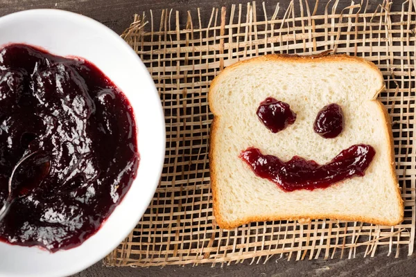 Breakfast smiley shaped bread with cherry jam — Stock Photo, Image