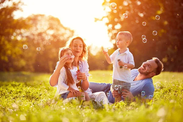 Rodina s dětmi ránu mýdlové bubliny — Stock fotografie