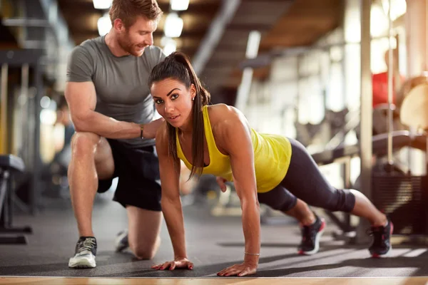 Meisje doet push ups met trainer helpt — Stockfoto