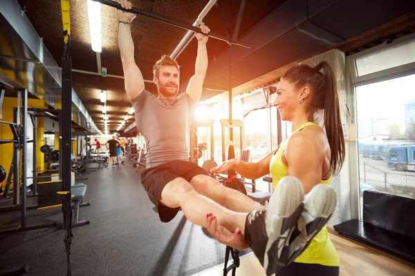 Man met trainer in de sportschool op fitnessapparatuur — Stockfoto