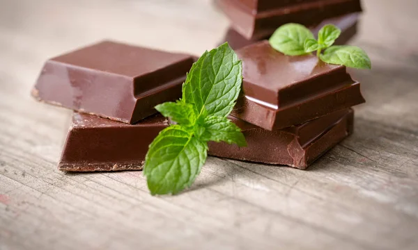 Dark chocolate pieces with a leaf of mint — Stock Photo, Image