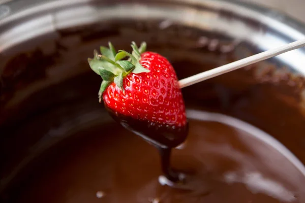 Dipping strawberries in dark chocolate — Stock Photo, Image