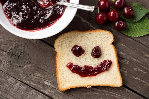 Shaped happy face bread with cherry jam — Stock Photo, Image