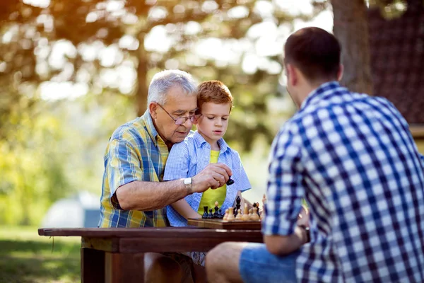 Abuelo enseñando ajedrez a su nieto — Foto de Stock