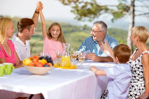 Family smiling and playing card in nature — Stock Photo, Image