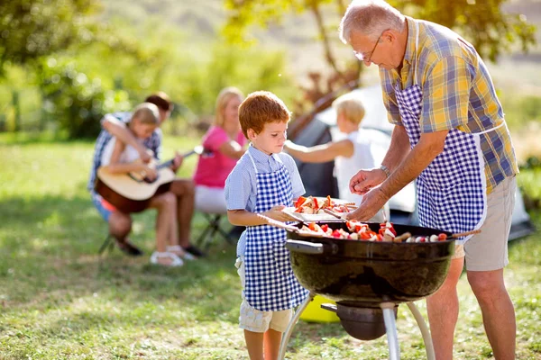 Grandfather and grandson at barbecue — Stock Photo, Image