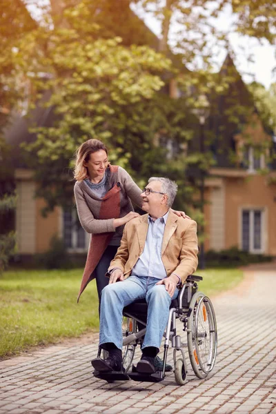 Médecine : fille aidante avec un aîné en fauteuil roulant — Photo